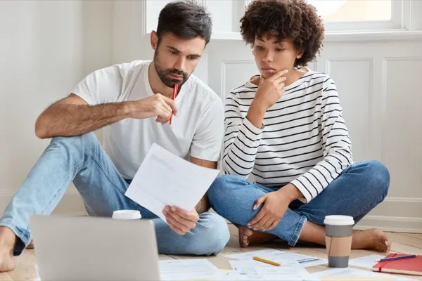 Young couple reviewing California purchase loan options and mortgage documents together
